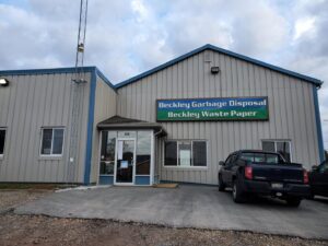 Overflowing garbage bins on a grassy curb, showing a typical junk removal job for Whitecap Waste in Beckley, WV.