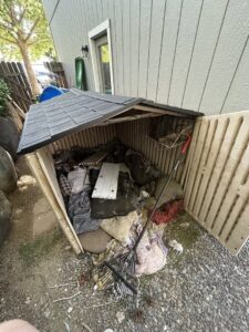 An overflowing outdoor storage shed filled with various junk items, ready for cleanout by Reno Junk Pros in Reno, NV.