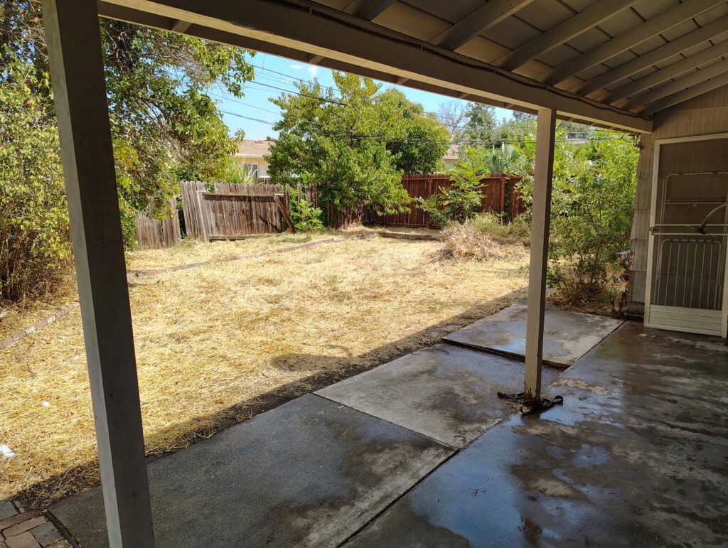 An overgrown backyard with scattered debris, indicating a yard waste removal job for Sac Junk in Rancho Cordova, CA