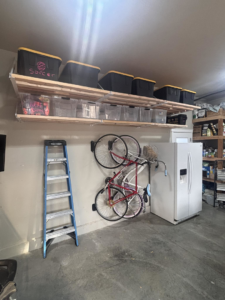 Overhead garage shelving and a wall-mounted bike rack installed in a home by Bend Garage Storage Solutions in Bend, OR