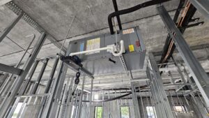 Overhead HVAC unit and ductwork installation within metal framing at a construction site by Belair Inc. in Saint Cloud, FL