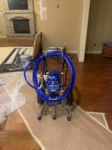 A professional paint sprayer set up in a room prepped for a painting job by Walrus Rock Construction LLC in Pacific, MO.