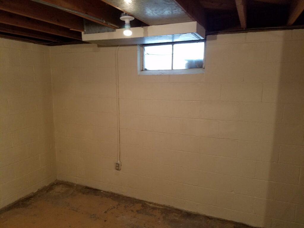 A newly painted basement wall with a window, part of a remodel by Rosewalls Handyman & Remodeling in Des Moines, IA.