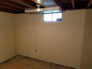 A newly painted basement wall with a window, part of a remodel by Rosewalls Handyman & Remodeling in Des Moines, IA.