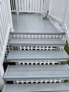 Newly painted grey outdoor deck stairs by CJP Construction handyman services in Pierce, NE.