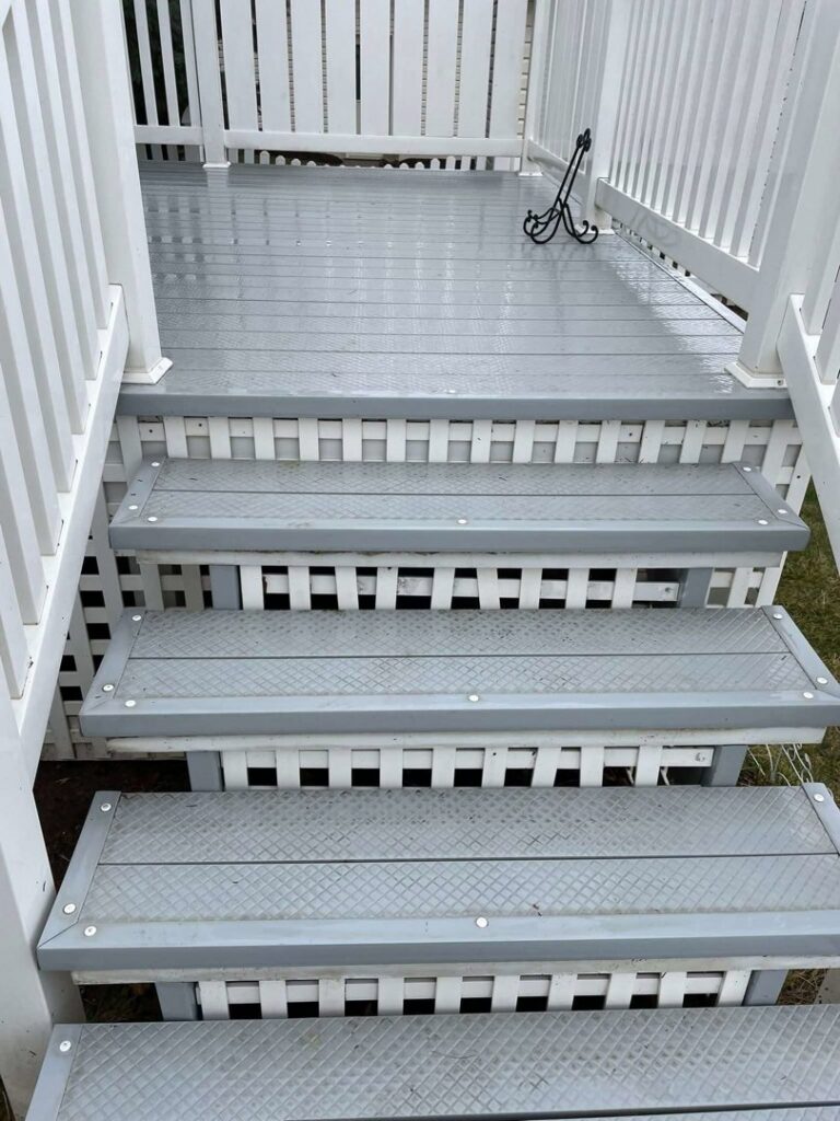 Newly painted grey outdoor deck stairs by CJP Construction handyman services in Pierce, NE.