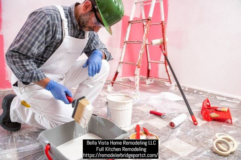 A painter in overalls and a hard hat preparing to paint during a kitchen remodel by Bella Vista Home Remodeling LLC in Bridgeport, CT.