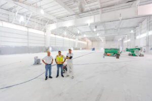 A painting crew standing in a large, newly painted industrial space by Alpine Painting and Sandblasting Contractors in Paterson, NJ.