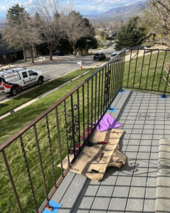 A metal deck railing being painted with tools and spray cans on a job site by Titan Handyman Services in Lewes, DE