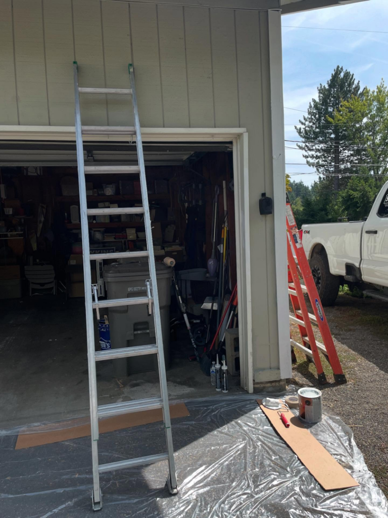 Ladders, paint cans, and drop cloths set up for a painting job by Shed Crafters in Sycamore, IL.
