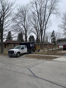 A Palasz Tree Service truck with a wood chipper attached, parked on a street in Milwaukee, WI.