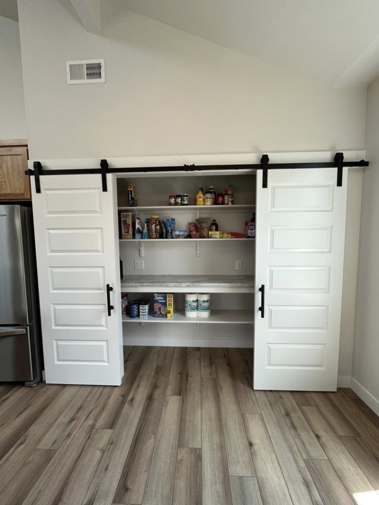 Pantry with newly installed barn doors and shelving by Denn Construction, Inc. in Medford, OR.