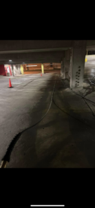 Pressure washing in progress on a parking garage floor by RWD Construction in San Antonio, TX.