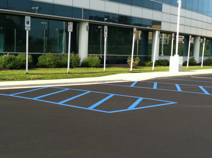 A parking lot with freshly painted blue handicapped parking lines by Empire Sealcoating in Albany, NY