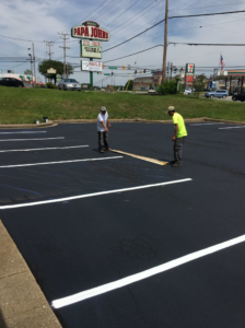Workers preparing for parking lot striping after sealcoating by Free State Contracting Company in Annapolis, MD