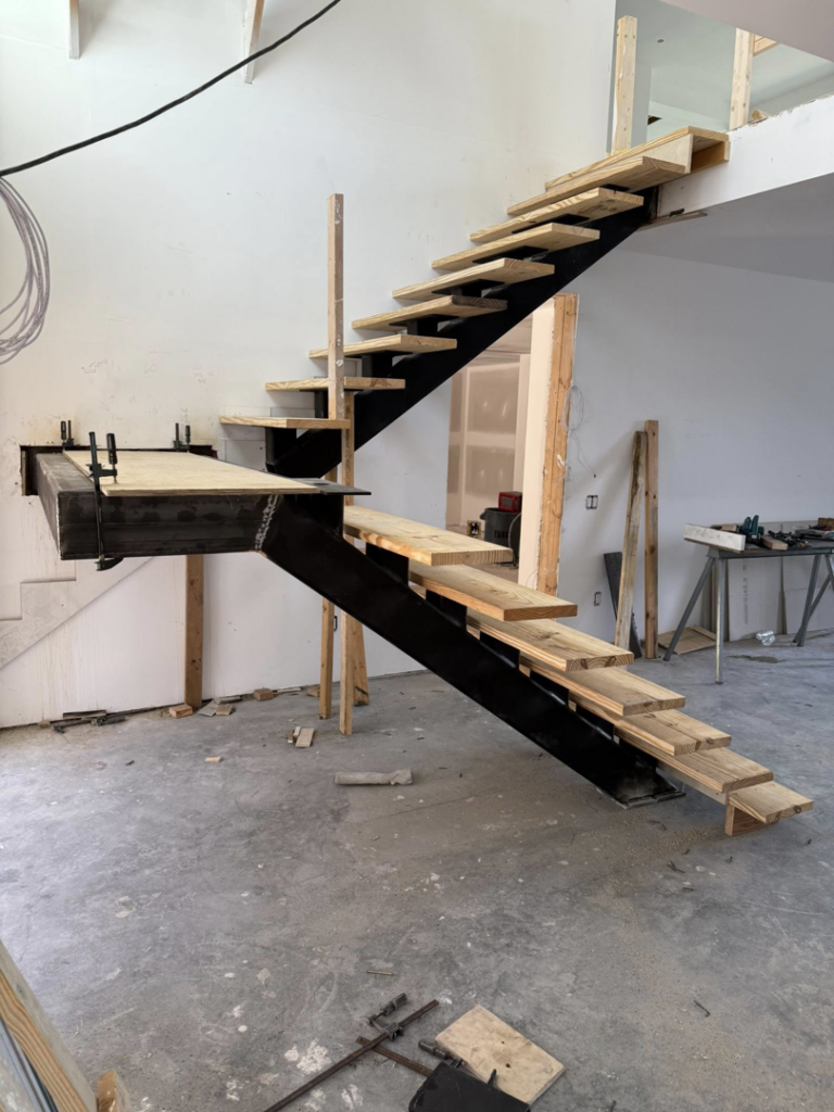 Partially built metal and wood stairs in a home under construction by Sanddollar Building & Remodeling Inc in Hilton Head Island, SC.