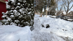 A partially cleared walkway with a shovel, showing snow removal work by Build Brothers in Providence, RI