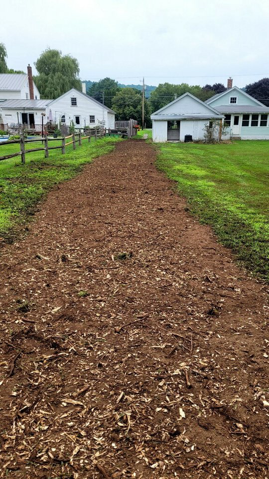 A residential path cleared of tree stumps and covered with fresh wood chips by Green Mtn Stump Grinding in Montpelier, VT.