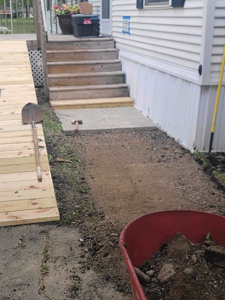 Pathway construction in progress with gravel and paving stones next to a wooden ramp, by Becker Services ND in West Fargo, ND.
