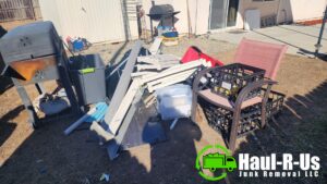 A cluttered patio area with furniture, bags of trash, and a bicycle, ready for junk removal by Haul-R-Us Junk Removal LLC in Fresno, CA.