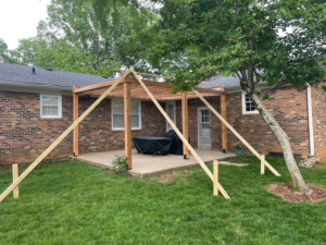 Wooden patio cover construction in progress with temporary supports by HC Homes & Consulting in Bowling Green, KY.