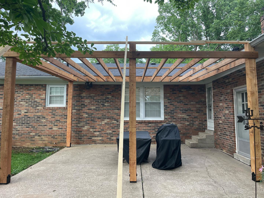 The wooden frame of a patio cover under installation by HC Homes & Consulting in Bowling Green, KY.