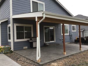 A custom patio cover installed over a stamped concrete patio by Lnk Deck & Remodels, LLC in Aurora, CO.