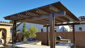 A custom patio cover or pergola structure over an outdoor kitchen, installed by Phoenix Rain Gutters and Sun Protection in Glendale, AZ.