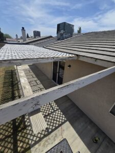 An old patio cover with peeling paint and lattice, indicating a need for repair by Bakoboy Enterprise Inc in Bakersfield, CA.