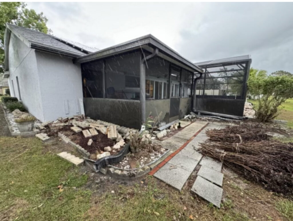 A patio area with broken pavers, construction debris, and bundled yard waste, indicating a cleanup job for Route Junk in Orlando, FL.