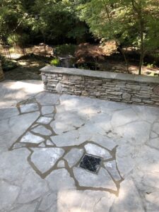 A stone patio with a newly installed drain grate by Drip Dry Drainage in Cramerton, NC.