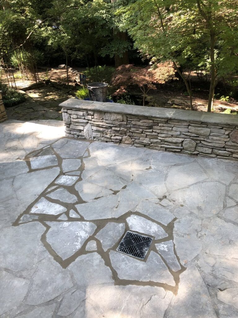A stone patio with a newly installed drain grate by Drip Dry Drainage in Cramerton, NC.