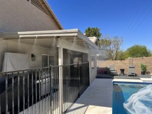 A high-quality mist system installed on a patio next to a pool with a safety fence by Mr. Mister in Surprise, AZ