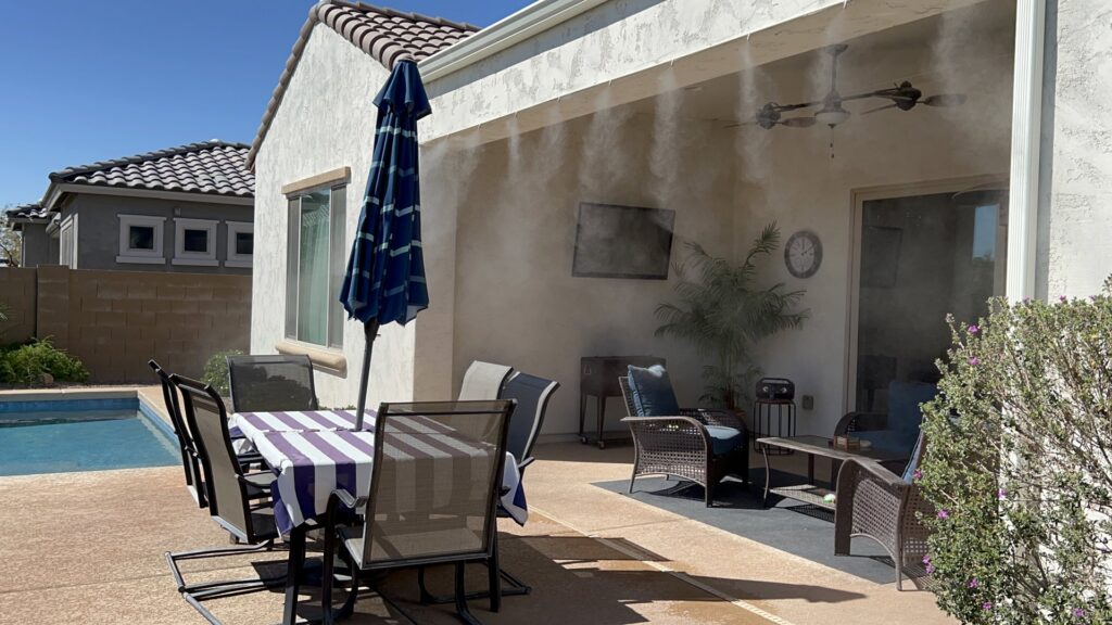 A high-quality mist system installed on a patio next to a pool with an umbrella by Mr. Mister in Surprise, AZ
