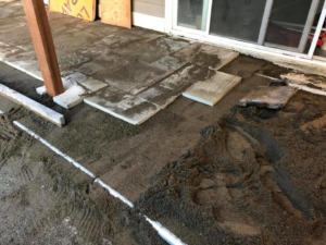 Patio pavers being installed on a prepared base next to a house by M.C.Dirtworks in Caldwell, ID.