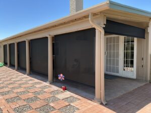 A patio area equipped with roll-down shades or screens for sun protection, installed by Phoenix Rain Gutters and Sun Protection in Glendale, AZ.