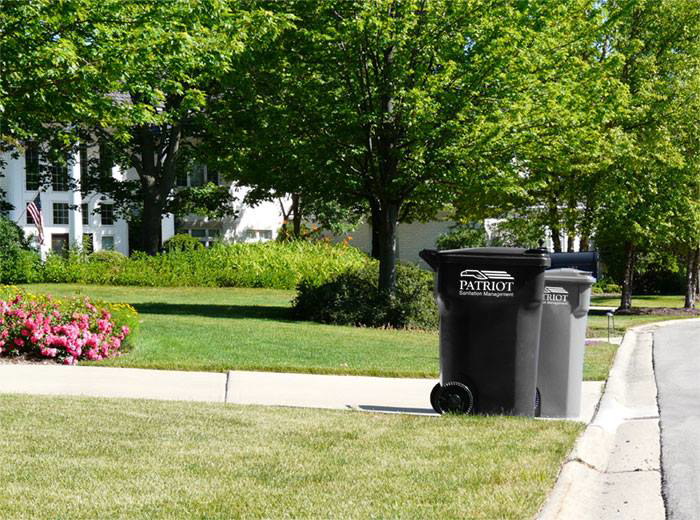 Patriot Sanitation Management residential waste bins placed on a curb for collection in Raleigh, NC