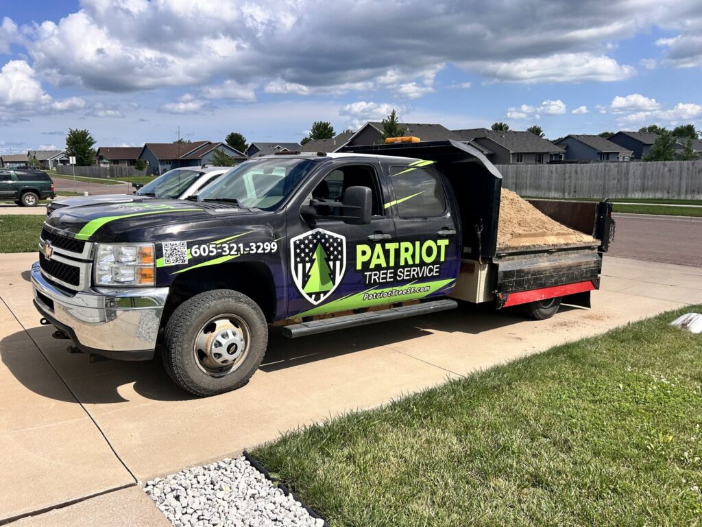 A Patriot Tree Service dump truck filled with wood chips, ready for hauling in Sioux Falls, SD