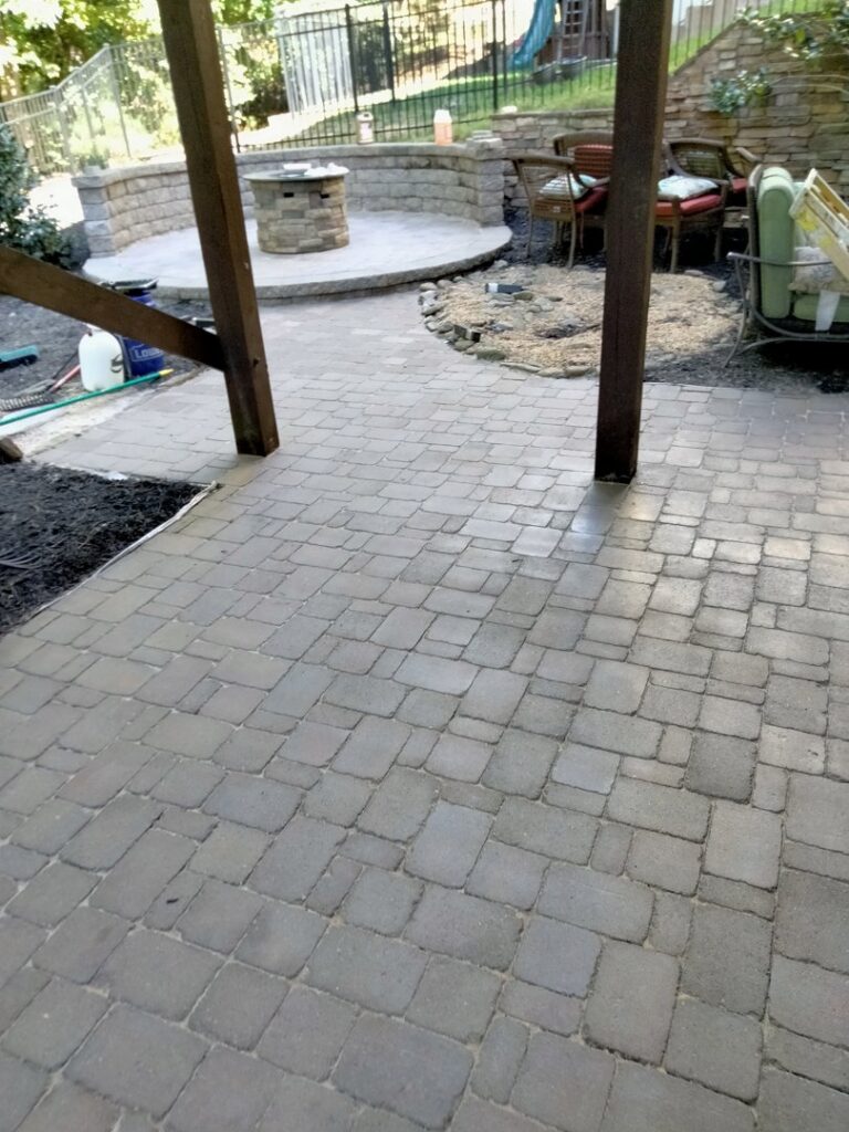 A newly paved patio area constructed under a wooden deck by Mels Haul & Junk Removal in Raleigh, NC.