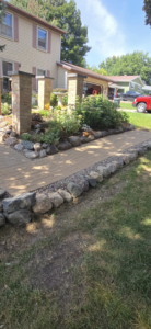 A paved walkway with stone borders and brick pillars by Schwoegler Remodeling in Madison, WI