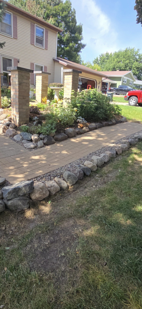 A paved walkway with stone borders and brick pillars by Schwoegler Remodeling in Madison, WI