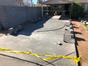 Paver driveway installation in progress with materials and caution tape by Ken's Masonry, LLC in Chandler, AZ.