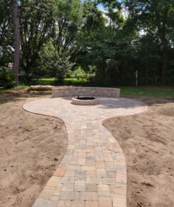 A newly constructed paver pathway leading to a patio with a fire pit by Keystone Design in Tallahassee, FL.