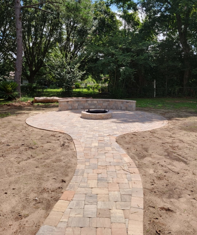 A newly constructed paver pathway leading to a patio with a fire pit by Keystone Design in Tallahassee, FL.