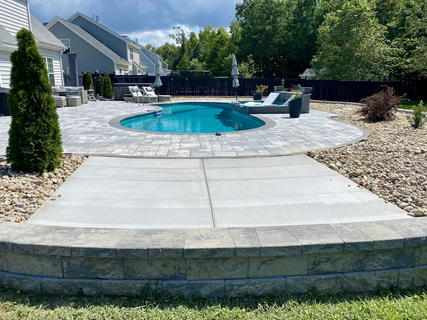 A beautifully installed paver patio and concrete pool deck by McGhee's Concrete in Chesapeake, VA.