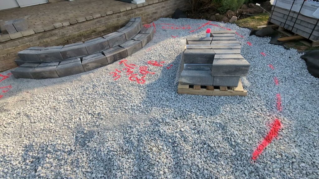 A paver patio construction project in progress with materials on site by Wildflower Landscapers LLC in Larsen, WI