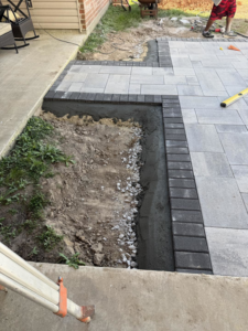 Paver patio installation in progress with concrete and tools by Nugent Construction LLC in River Edge, NJ.