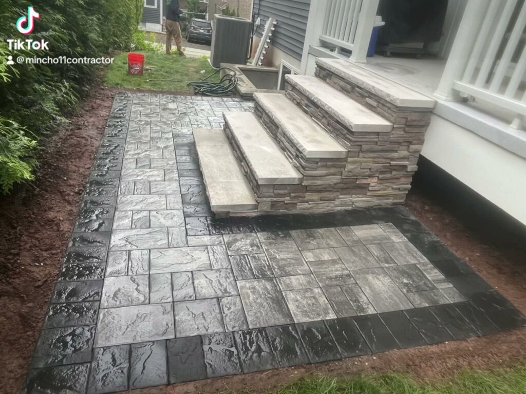 Newly installed paver patio and stone steps leading to a house by Mincho Contractor LLC in Jersey City, NJ