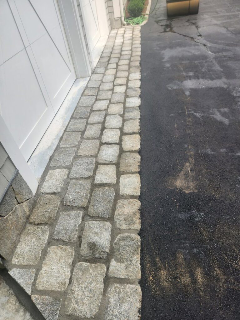 Paver stone border installed next to a garage door by Leo Brothers Contracting in Danbury, CT.