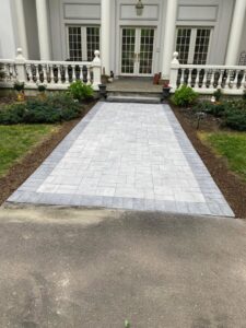 A newly installed paver walkway leading to a house entrance by Leo Brothers Contracting in Danbury, CT.